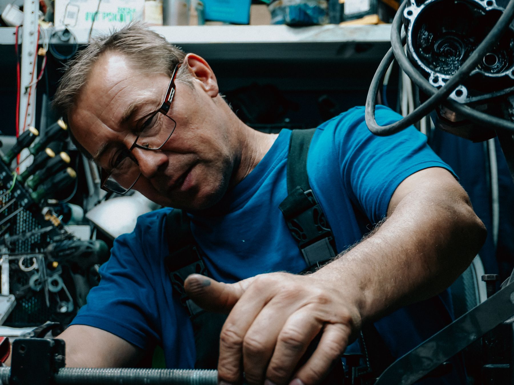 Mechanic working on an engine in a dark workshop